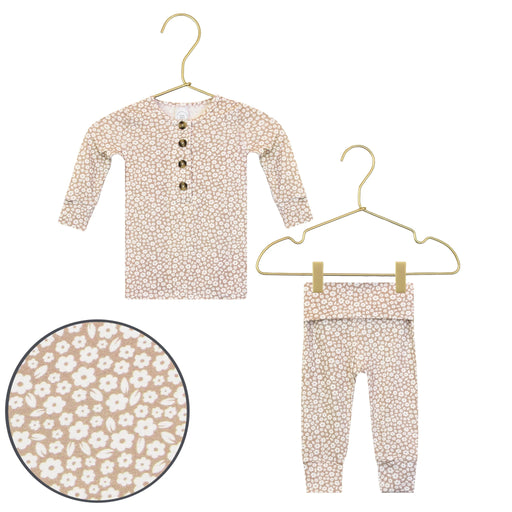 Children's floral outfit with top and pants on hangers against a white background