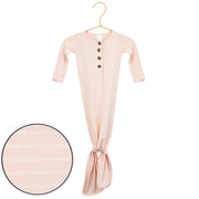 Pink baby gown with buttons on a hanger against a white background
