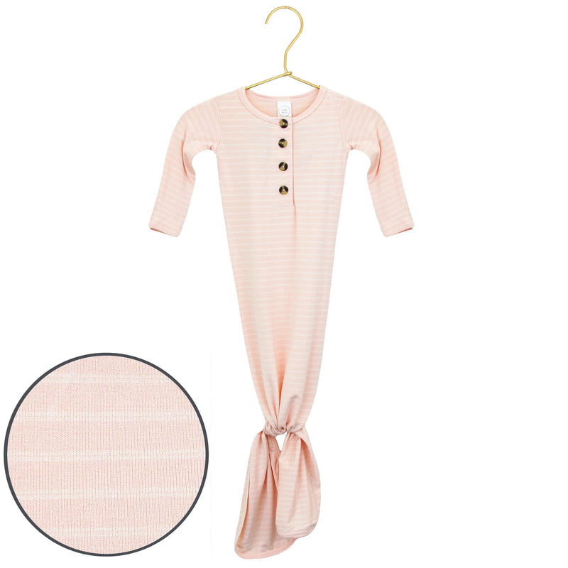Pink baby gown with buttons on a hanger against a white background
