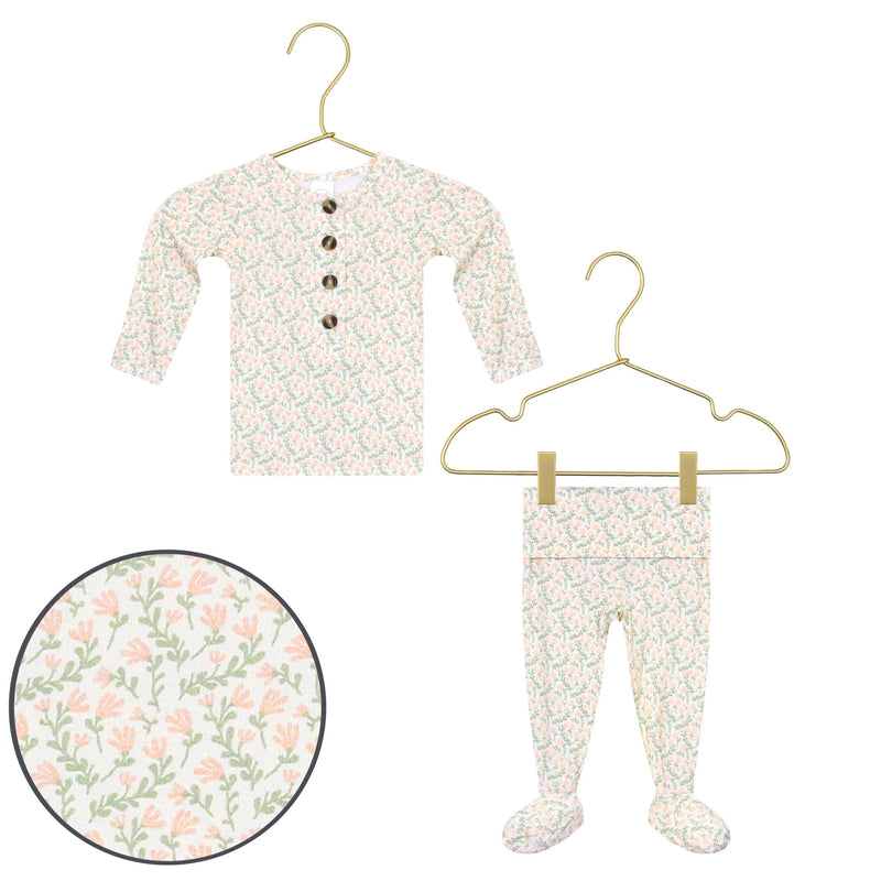 Baby outfit with floral pattern on a hanger against a white background