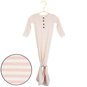 A baby gown with long sleeves and a tie at the feet, featuring horizontal peach and white stripes, hanging on a gold hanger with a circular fabric detail inset.