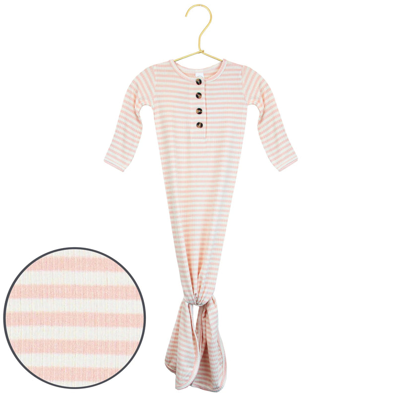 A baby gown with long sleeves and a tie at the feet, featuring horizontal peach and white stripes, hanging on a gold hanger with a circular fabric detail inset.