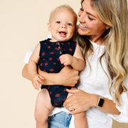 Woman holding a baby with a plain background