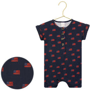 Children's romper with American flag pattern on a hanger against a white background