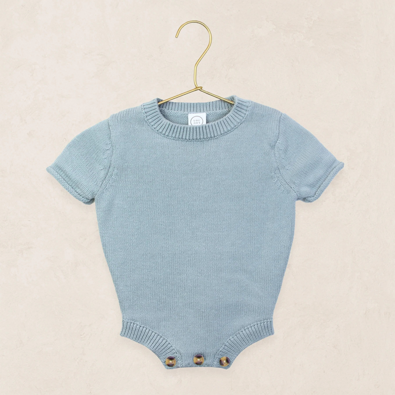Blue baby romper on a hanger against a beige background