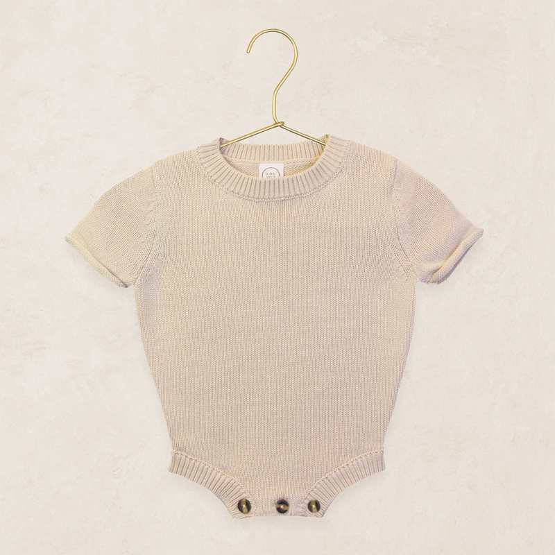 Tan baby romper on a hanger against a beige background