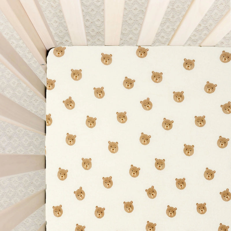 Lou Lou & Co Teddy print crib sheet with beige bear faces on cream background and snug elastic edges