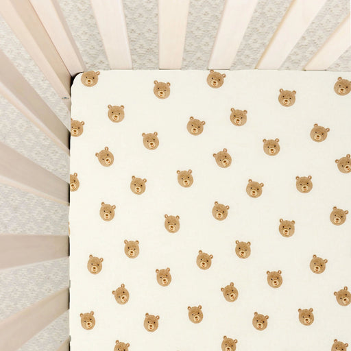 Lou Lou & Co Teddy print crib sheet with beige bear faces on cream background and snug elastic edges
