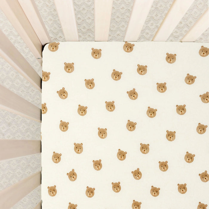 Lou Lou & Co Teddy print crib sheet with beige bear faces on cream background and snug elastic edges