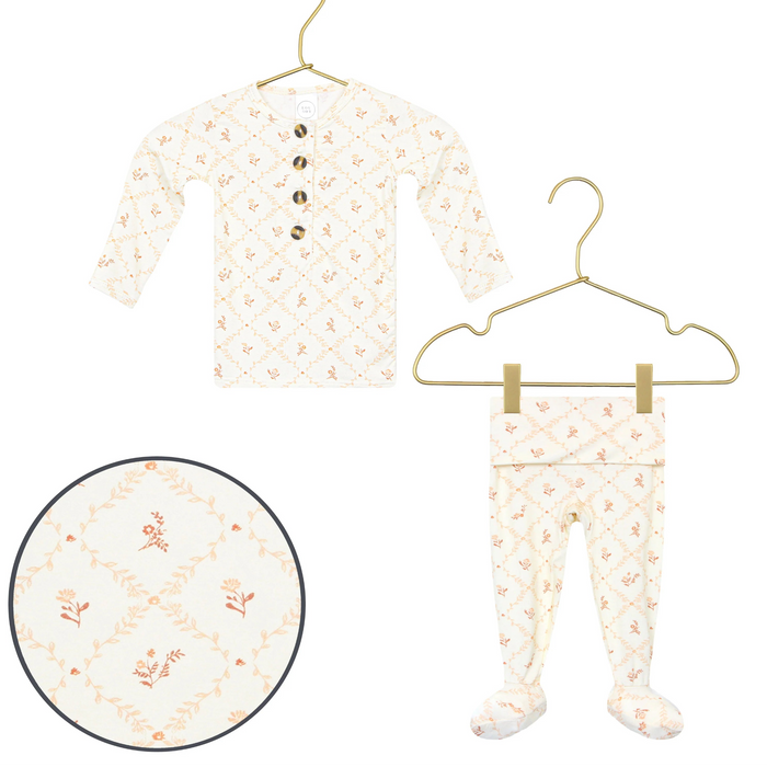 Lou Lou & Co Annie newborn top and bottom set in cream with peach floral print displayed on gold hangers