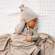 Newborn baby wearing Lou Lou & Co Banks striped outfit with matching hat and pacifier lying on white blanket