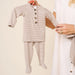 Lou Lou & Co Banks newborn striped top and bottom set in beige and white being held on hanger by adult in neutral outfit