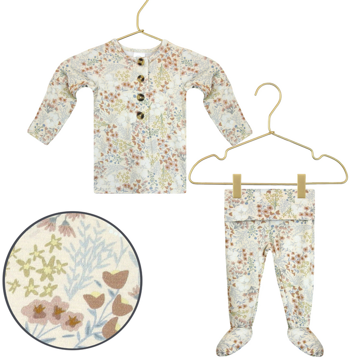 Lou Lou & Co Pearl newborn top and bottom set featuring a soft floral print in cream, dusty rose, sage, and blue tones displayed on gold hangers