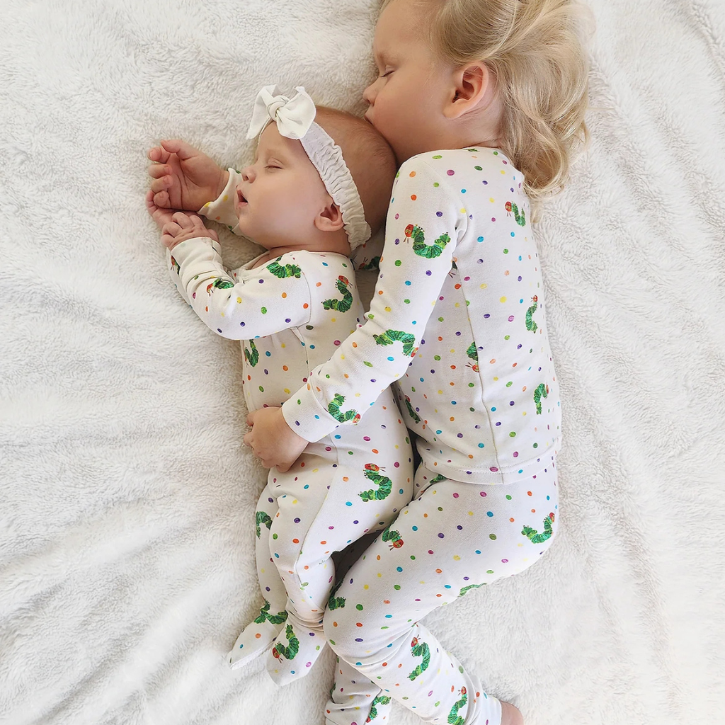 toddler and baby sleeping in very hungry caterpillar organic cotton pajamas