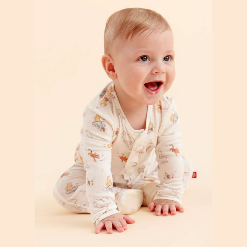 Baby wearing the magnetic footie while sitting and smiling