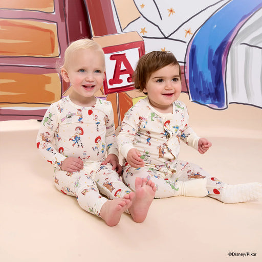 Two children wearing pajamas with a colorful background
