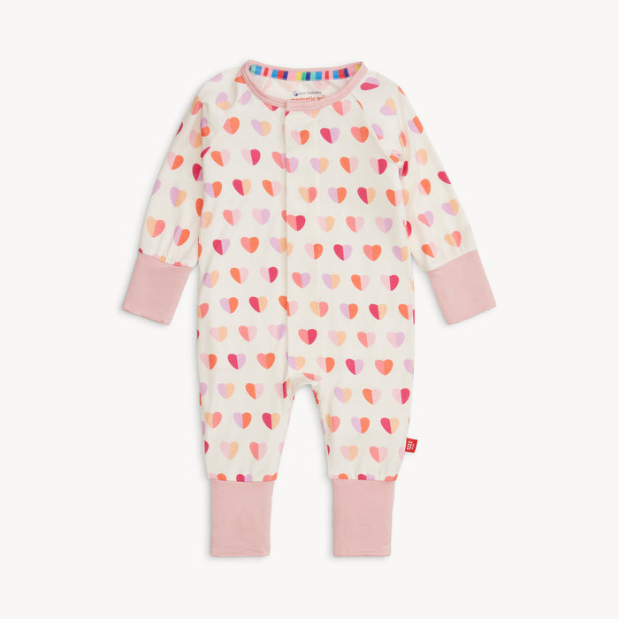 Full view of Magnetic Me Convertible Coverall in Pink XOXO print with pink cuffs and allover heart pattern