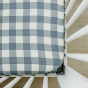 Mebie Baby Muslin Crib Sheet in Dusty Blue Gingham fitted on a mattress in a white crib
