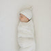 newborn swaddled on taupe stripe ribbed bamboo crib sheet top view