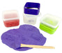 Set of colorful silicone mold containers with a purple mold and wooden spatula on a white background