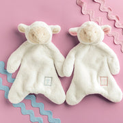 Mud Pie Lamb plush woobie loveys in blue and pink cross styles on a pink background