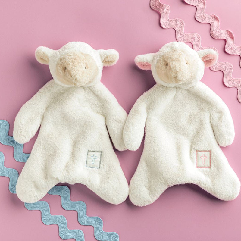 Mud Pie Lamb plush woobie loveys in blue and pink cross styles on a pink background