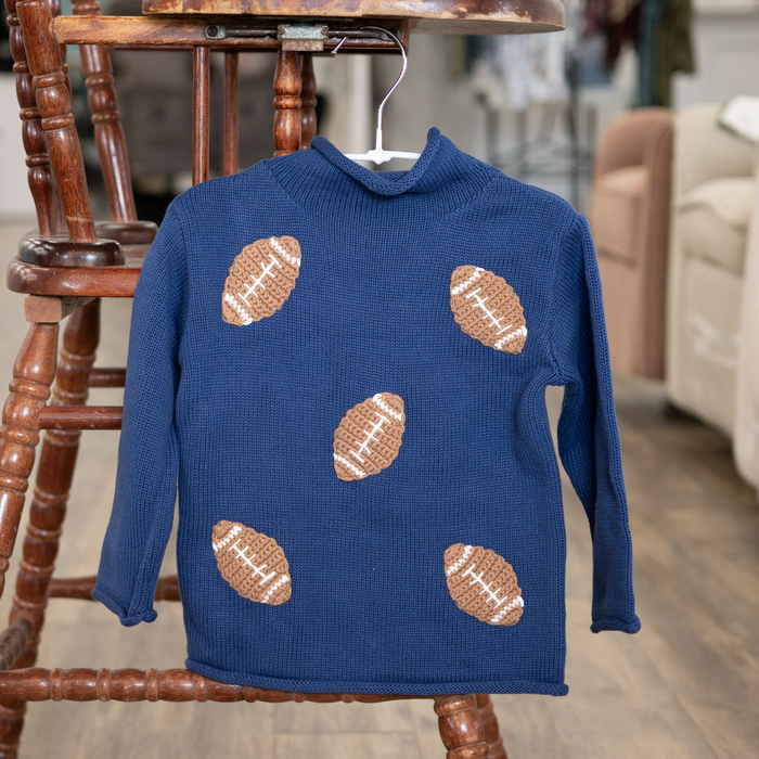 Blue sweater with football patterns on a wooden chair in a room setting
