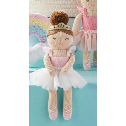 Toy ballerina doll with a rainbow and another doll in the background
