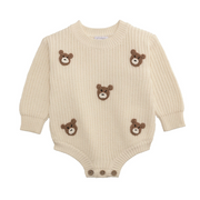 Beige baby romper with teddy bear appliqués on a white background