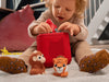 Child playing with My First Tonies Jungle Set figures and a Toniebox on a table