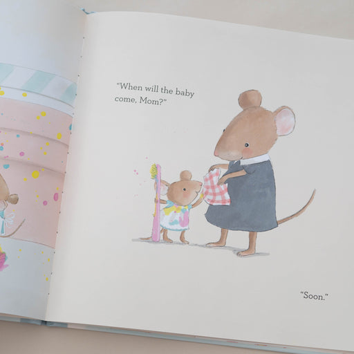 Illustrated book page with a mouse holding a baby mouse, on a plain background.