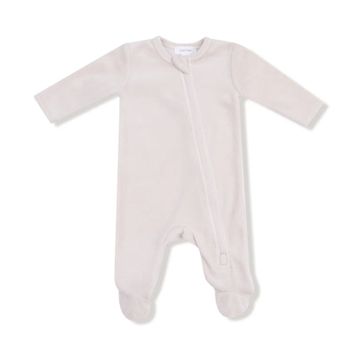 A soft oatmilk-colored velour footie with a diagonal zipper and built-in feet.