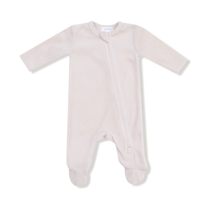 A soft oatmilk-colored velour footie with a diagonal zipper and built-in feet.