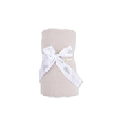 Folded beige fabric with a white ribbon on a white background