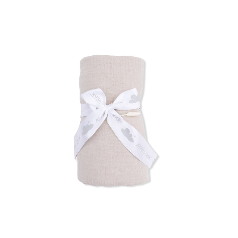Folded beige fabric with a white ribbon on a white background
