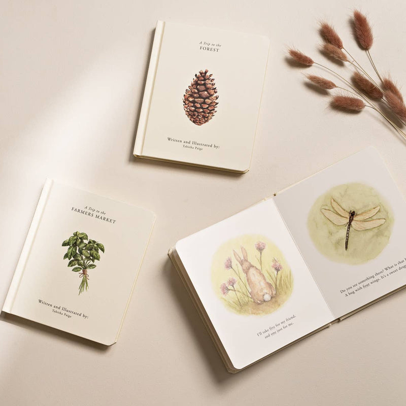 Three books with botanical illustrations on a beige surface