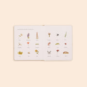 Illustrated book with various plants and insects on a beige background