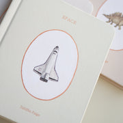 board book with space shuttle illustration on a beige background