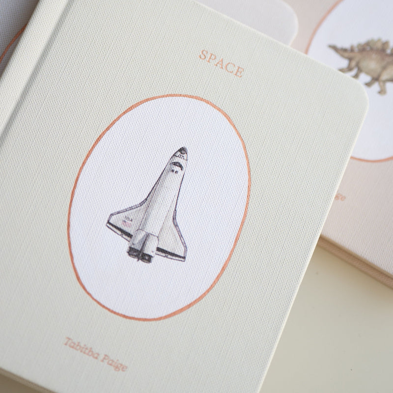 board book with space shuttle illustration on a beige background