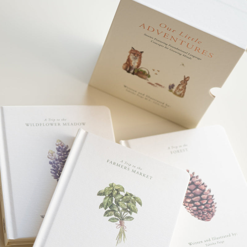 Three books with nature-themed illustrations on a light surface