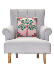 Gray armchair with a decorative pillow featuring a palm tree design on a white background