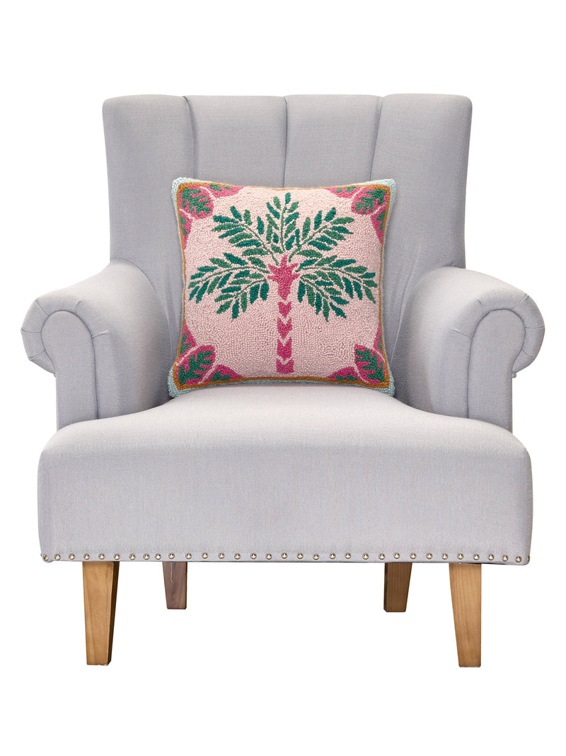 Gray armchair with a decorative pillow featuring a palm tree design on a white background