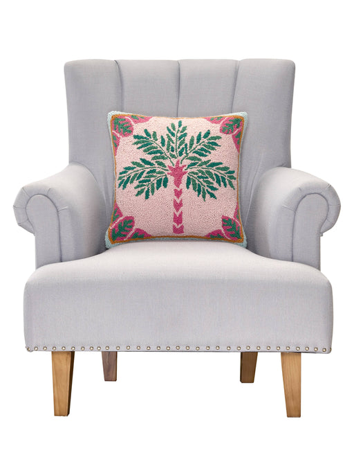 Gray armchair with a decorative pillow featuring a palm tree design on a white background