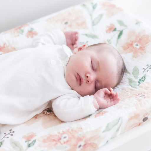 Sleeping baby lying on Parker Floral changing pad cover