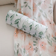 Rolled Parker swaddle resting on matching floral muslin fabric