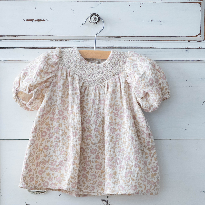 Floral dress on a hanger against a rustic wooden background