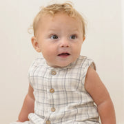 Baby wearing a checkered outfit with a plain background