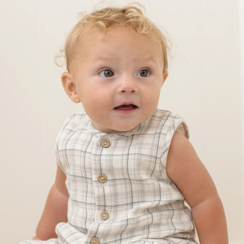 Baby wearing a checkered outfit with a plain background