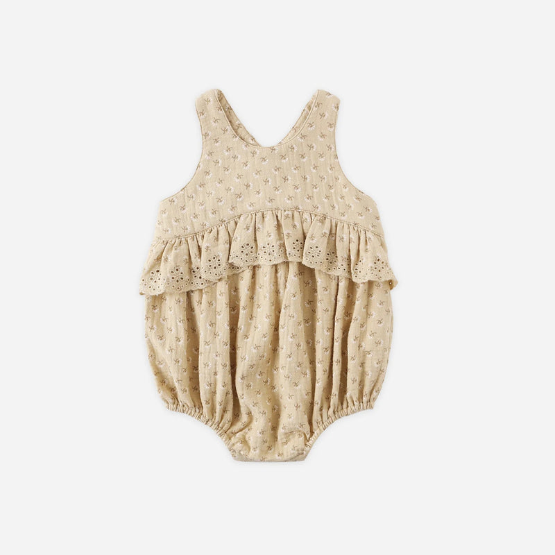 Beige baby romper with lace details on a white background
