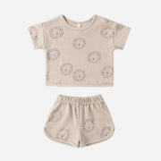 Beige children's outfit with lion patterns on a white background